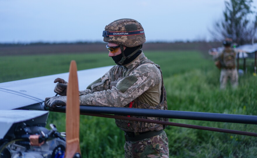 A soldier performs maintenance on a long-range drone before a launch.