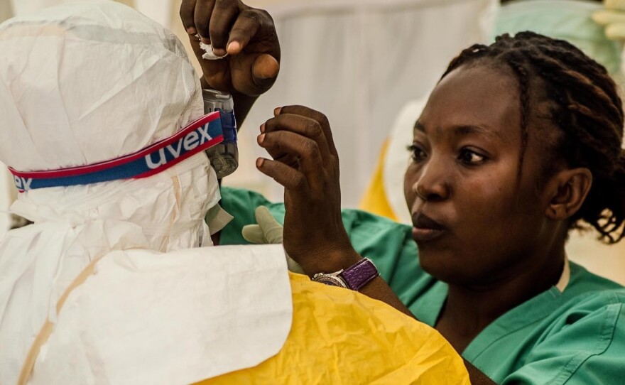 A nurse helps health workers suit up before treating Ebola patients at an isolation ward run by Doctors Without Borders in Kailahun, Sierra Leone.
