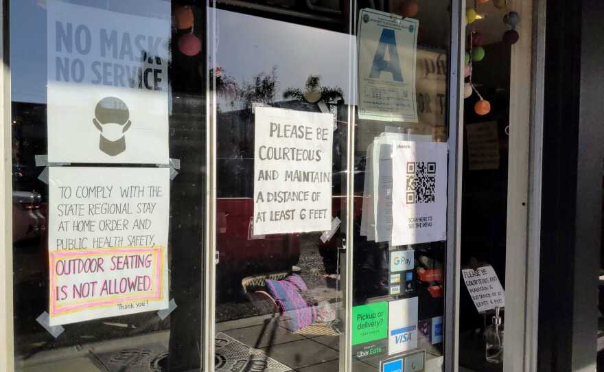 Signs outside the Plumeria Vegetarian Restaurant in Encinitas advising patrons that masks are required inside the establishment, Jan. 2, 2021.