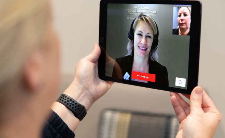 Dr. Margaret Paulson interacts with a patient via a tablet as part of Mayo Clinic's home-based hospital care program. Paulson says once patients understand that hospital-at-home care does not mean less care, they embrace it.