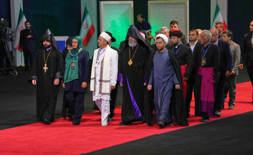 Iranian religious leaders and other mourners walk past the coffins of slain Iranian Supreme Leader Ayatollah Ali Khamenei and members of his family during a viewing ceremony ahead of the dayslong funeral ceremonies at the Imam Khomeini Mosalla Grand Mosque in Tehran, Iran, Friday, July 3, 2026.