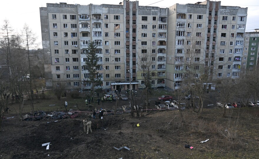 Lviv: Ukrainian firefighters and local residents inspect a damaged building and its surroundings.