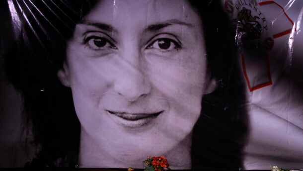 Flowers and a candle lie in front of a portrait of slain investigative journalist Daphne Caruana Galizia during a vigil outside the law courts in Valletta, Malta, Oct. 16, 2018.