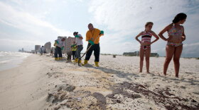 BP workers shovel oil and sand along a 700-yard long strip of oil that washed up on the beach in Gulf Shores, Ala., on Friday.