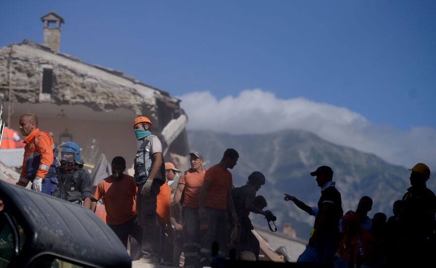 Volunteers move rubble and debris during search operations in the town of Amatrice on Wednesday after a powerful earthquake rocked central Italy.