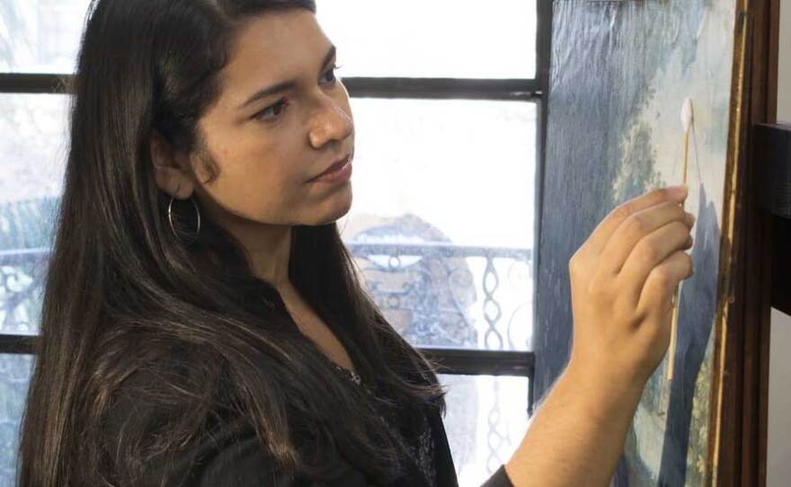 Art conservator Bianca Garcia cleans a painting. This month, the Balboa Art Conservation Center and A Reason to Survive are set to begin gathering protest art to preserve, archive and potentially prepare to exhibit. 