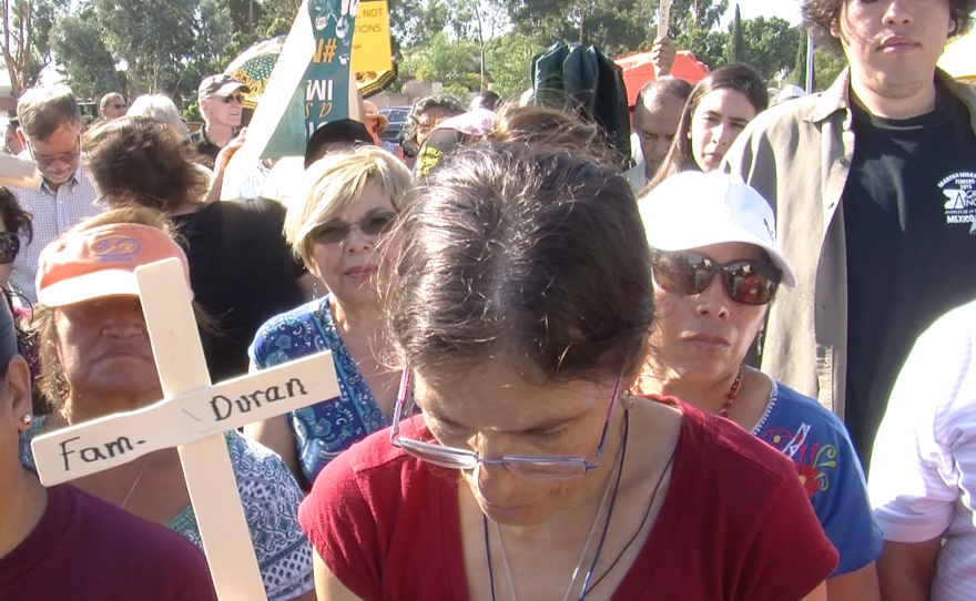 Audience members watch the unveiling of a memorial wall at a San Ysidro church, September 20, 2015.