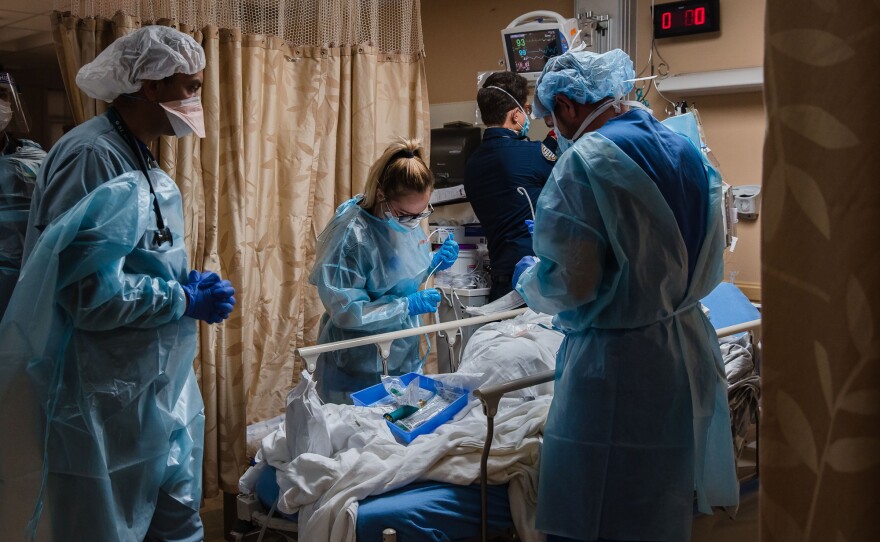 Health care workers tend to a patient with COVID-19, in a COVID holding pod at Providence St. Mary Medical Center in Apple Valley, California on Jan. 11, 2021.