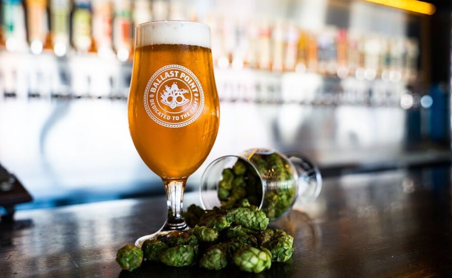 A glass of Ballast Point beer next to some hops in this undated photo.