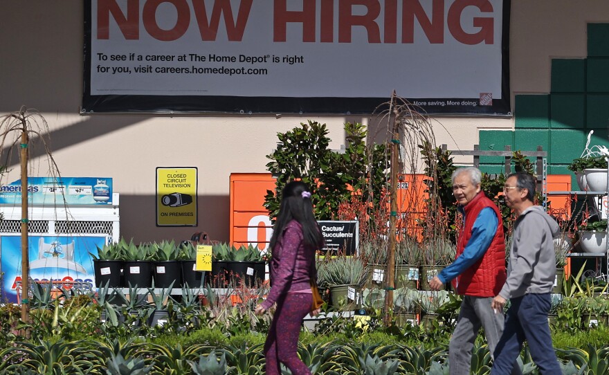 Hiring accelerated in the U.S. in March, adding 303,000 jobs, according to a report from the Bureau of Labor Statistics. The unemployment rate dipped to 3.8%, staying under 4% for more than two full years. People walk past a Home Depot in San Rafael, Calif.