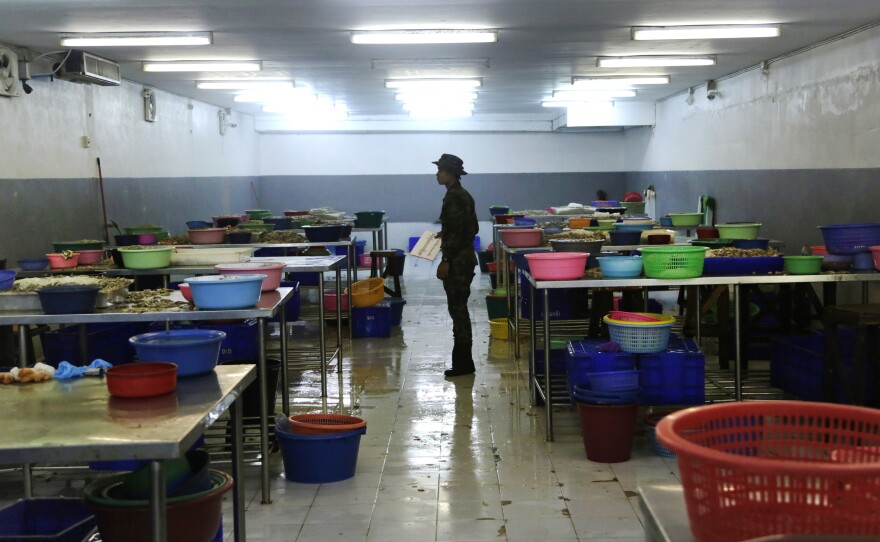 A Thai soldier stands between abandoned workstations during a raid on a shrimp shed in Samut Sakhon, Thailand. The Associated Press won a Pulitzer Prize for public service for its report "Seafood from Slaves."