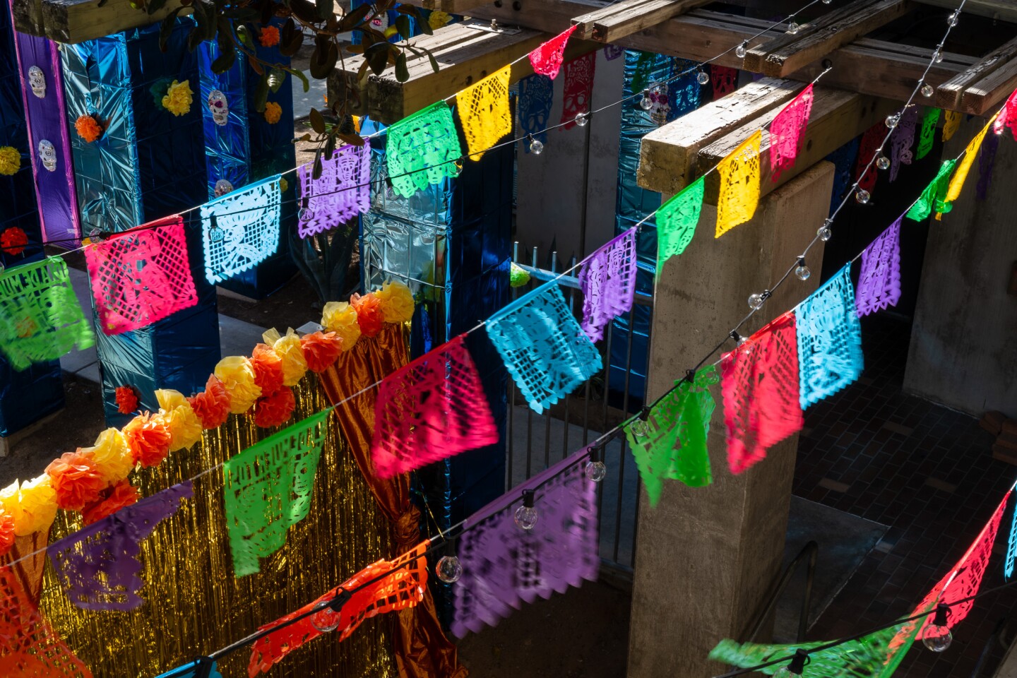 Papel picado, one of many traditional decorations for Día de Muertos, blows in the wind above the main patio at the Sherman Heights Community Center in San Diego on Oct. 17, 2023.