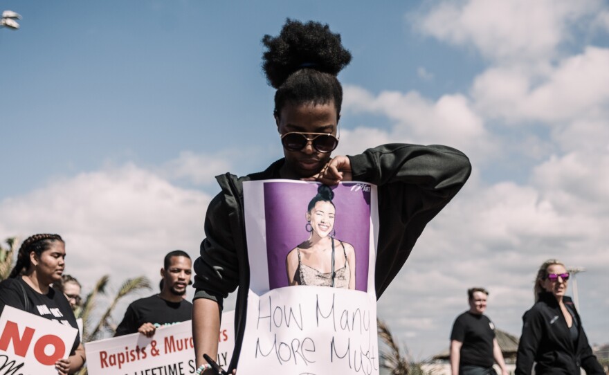 A woman holds a sign as she takes part in a march against gender based violence at the North Beach in Durban in 2019.