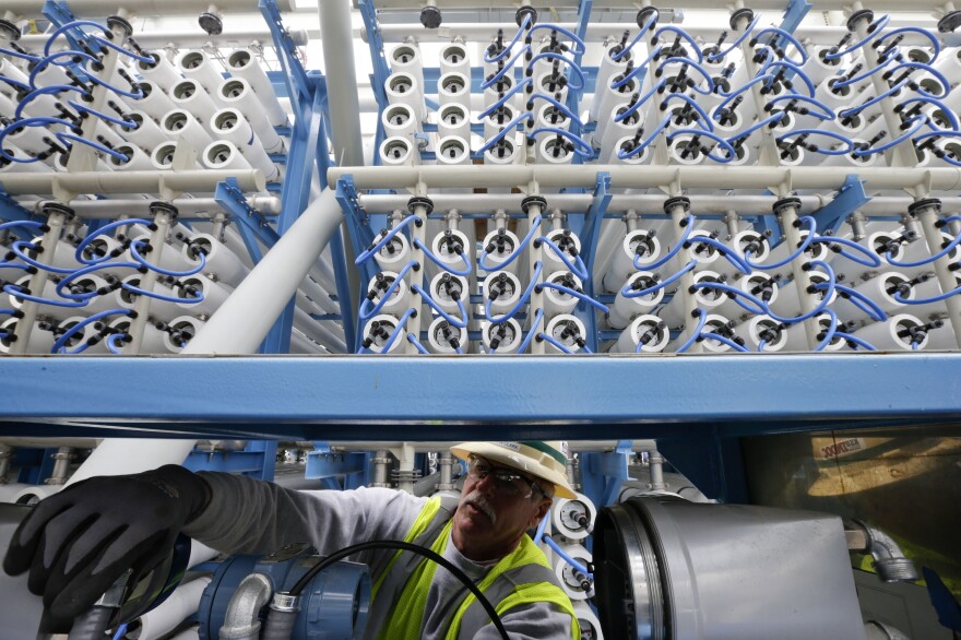 In a Wednesday, March 11, 2015 photo, worker adjusts equipment among some of the 2000 pressure vessels that will be used to convert seawater into fresh water through reverse osmosis in the western hemisphere's largest desalination plant, in Carlsbad, Calif.
