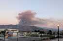Smoke from the Border Fire near Otay Mountain rises into the sky at dusk on Jan. 20, 2025.