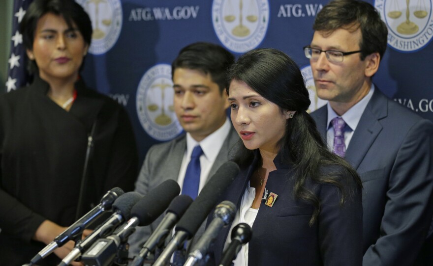 Faride Cuevas, a participant in the Deferred Action for Childhood Arrivals, or DACA, program, talks to reporters Wednesday in Seattle as Washington Attorney General Bob Ferguson and other DACA participants look on.