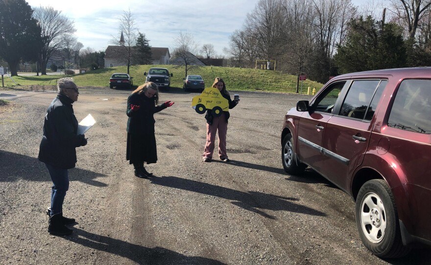 Lay ministers Darlene Washington (from left) and Jackie Waymire and Pastor Faith Wilkerson pray with a couple in the Centenary Methodist Church parking lot in Shady Side, Md.