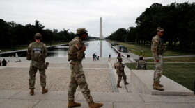 Members of the National Guard patrol as National Park Service workers clean algae from the Lincoln Memorial Reflecting Pool in Washington, D.C.