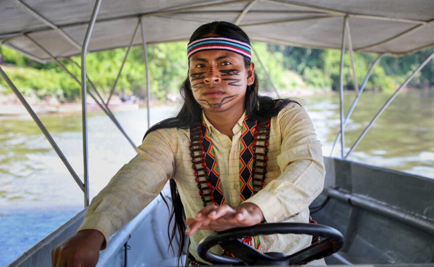 Luciano Peas, a 27-year-old Indigenous boat driver from the village of Sharamentsa, steers one of the solar-powered canoes. The project is run on the ground exclusively by Indigenous people.