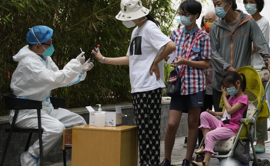Residents line up for mass COVID tests, Monday, June 13, 2022, in Beijing.