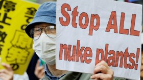 A man holds a placard during a march denouncing the use of nuclear  plants and power during a demonstration in Tokyo on May 1.