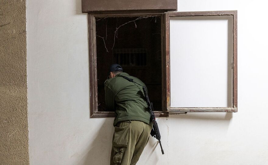 5 Nisan 2026'da, İsrail'in kuzeyindeki Hayfa kentinde İran'ın düzenlediği bir saldırıda yıkılan bir konut binasının enkazında arama kurtarma ekipleri çalışmalarını izlerken bir İsrail askeri olay yerini gözetliyor.