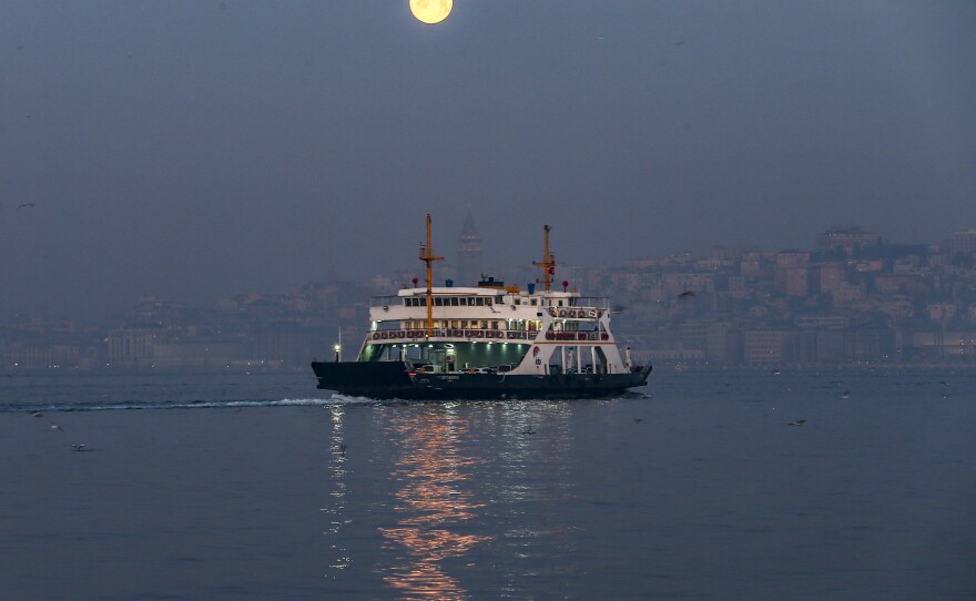 The full moon sets over the Bosphorus in Istanbul on Wednesday.