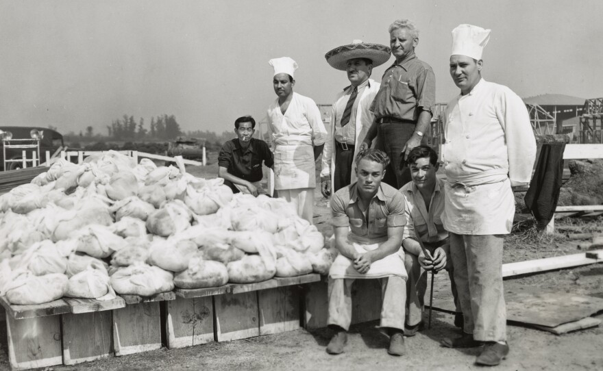 Men pose with piles of wrapped beef, ready for the barbecue pits, at a Los Angeles sheriff's barbecue. The end goal of the America Eats project was to assemble material for a book exploring "American cookery and the part it has played in national life, as exemplified in the group meals that preserve not only traditional dishes, but also transitional attitudes and customs."