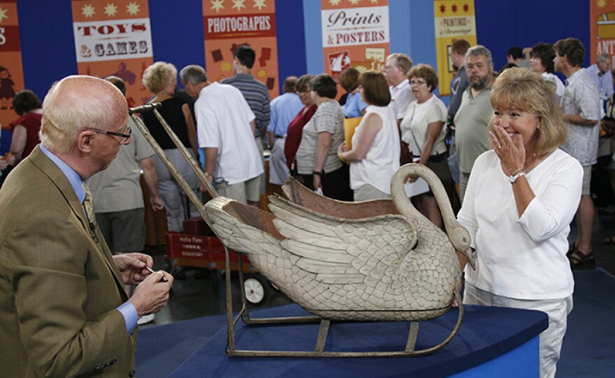 Allan Katz (left) appraises a child's swan sled, ca. 1880, in Milwaukee, Wis.