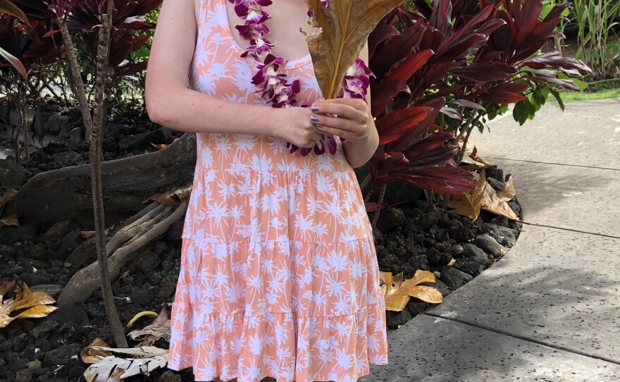 Mora holds a palm frond after stringing her own lei while on a family vacation.