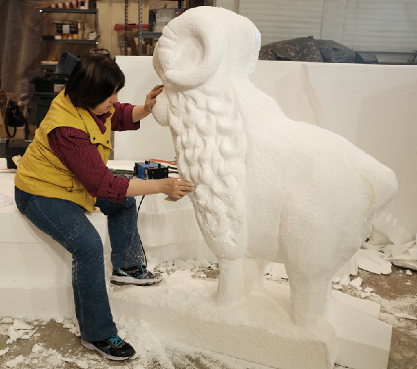 Yumei Hou carves a sheep out of styrofoam for a Chinese New Year float.