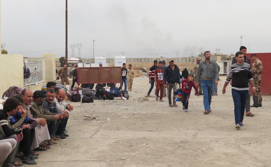 Civilians arriving at Scorpion Junction on the outskirts of Mosul where they are checked for suspected ties to ISIS.