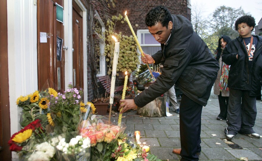 A man places flowers at the home of slain Dutch filmmaker Theo van Gogh in 2004. Van Gogh was killed by a Muslim radical after he made a film criticizing the way many women were treated in Islam.