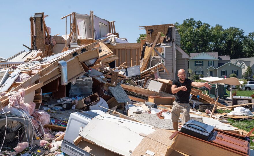 Sam Catrambone clears debris away from a friend's home that was damaged by a tornado in Mullica Hill, N.J., on Thursday after record-breaking rainfall brought by the remnants of Hurricane Ida that swept through the area.