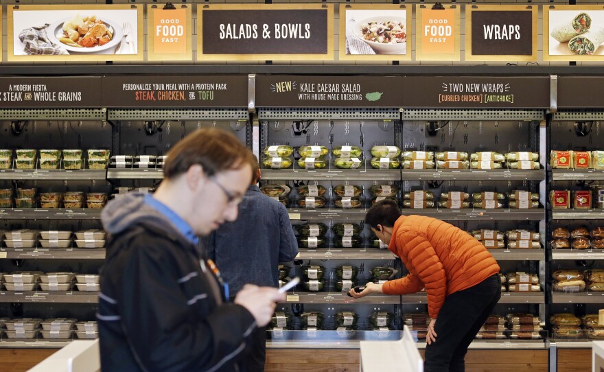 Shoppers roam through an Amazon Go store in April. The automated grocery, which had been restricted to Amazon employees, will be open to the public starting Monday.