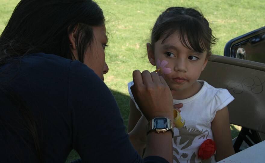 Two-year-old Jaklin sits to have her face painted at the celebration of life at Libby Lake Park in Oceanside, March 13, 2015.