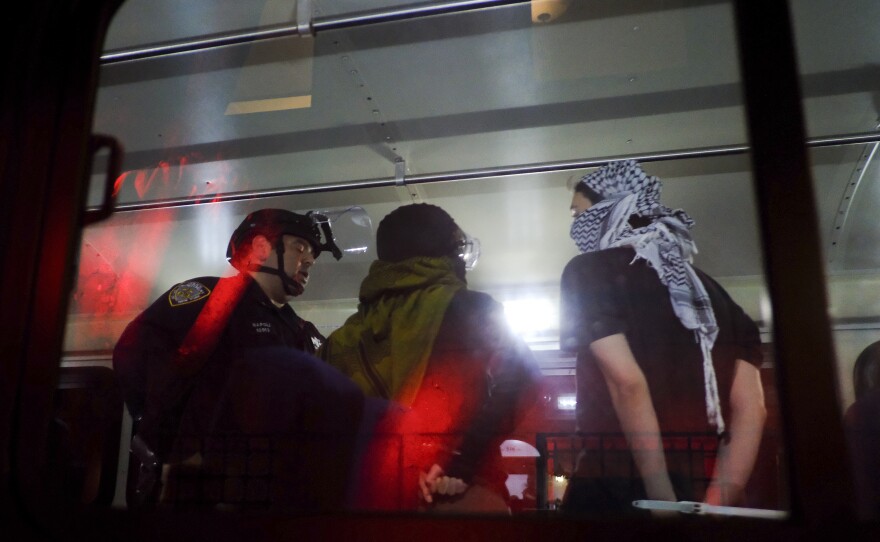 Members of the New York Police Department strategic response team load arrested protesters from Columbia University onto a bus, Tuesday, April 30, 2024, in New York.