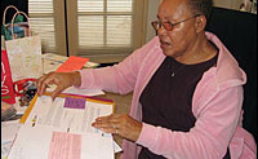Betty Larkins looks through a binder of the complicated paperwork leading up to the foreclosure on her house and her eviction. After her refinancing, Larkins' monthly mortage payment soared to $3,000 from $1,700, and she couldn't keep up with the payments.