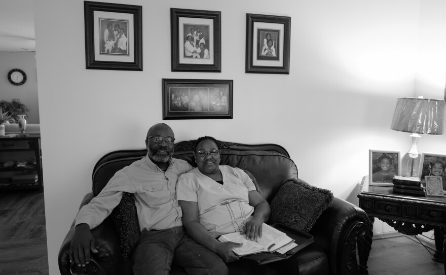 Delores Jetton and her husband, Sidney Jetton, sit on the couch in their home on April 14, 2022, surrounded by photos of their children and grandchildren. The hospital sold off the home health care unit due to financial strain but Jetton was retained as a hospice worker.