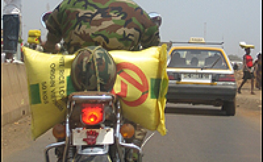 A soldier on a motorcycle carries a bag of rice through the streets of Conakry. "Last year, Guineans were fighting for the bag of rice," says political commentator Souleymane Diallo. "Now they are fighting for a plate of rice."