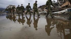Japanese military march during a search and rescue mission scouring the rubble of a village destroyed by the devastating earthquake and tsunami on March 15, 2011 in Rikuzentakata, Miyagi province, Japan. 