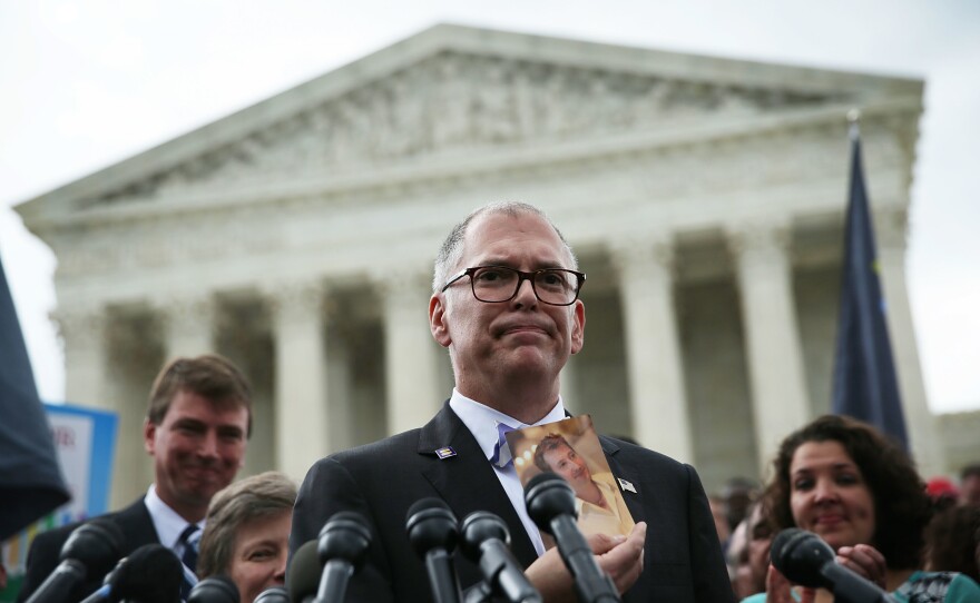Plaintiff Jim Obergefell holds a photo of his late husband John Arthur as he speaks to members of the media after the U.S. Supreme Court handed down a ruling in favor of same-sex marriage rights on June 26, 2015 outside the court in Washington, D.C.