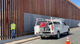 Worker is pictured welding sheets of metal onto the border wall in Calexico on May 5, 2021. 