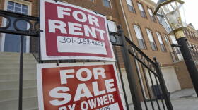 "For Sale" and "For Rent" signs are seen on the front of townhomes in Centreville, Va.