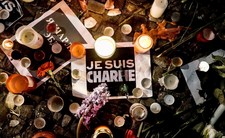 Papers reading "Je Suis Charlie" — "I am Charlie" — are left near candles at a vigil in front of the French Embassy in Berlin.