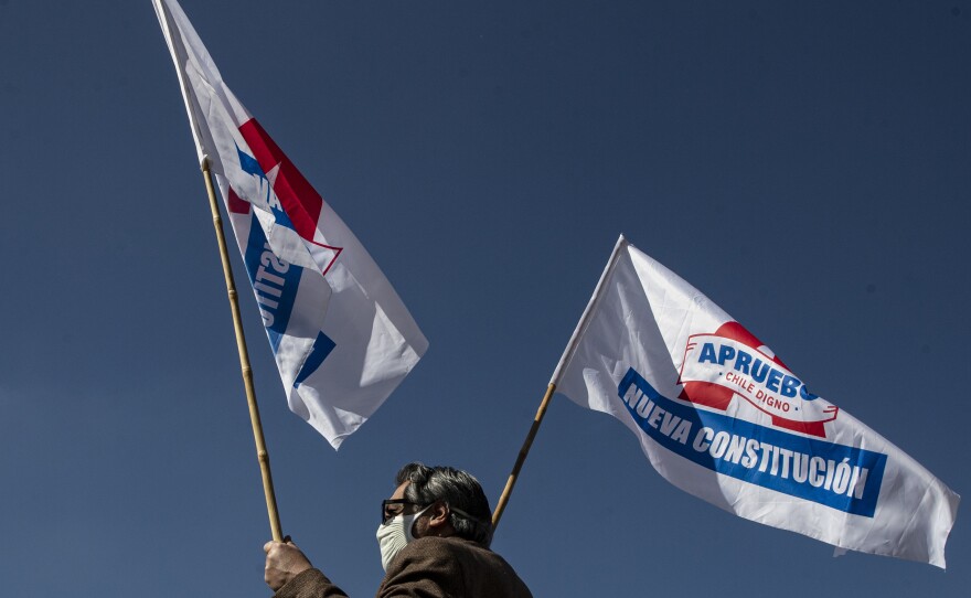 A man waves campaign flags in favor of a new constitution ahead of a referendum on the matter in Santiago, Chile, on Aug. 26. In a referendum on Sunday, Chileans will vote whether to scrap the constitution from the dictatorship of Gen. Augusto Pinochet.