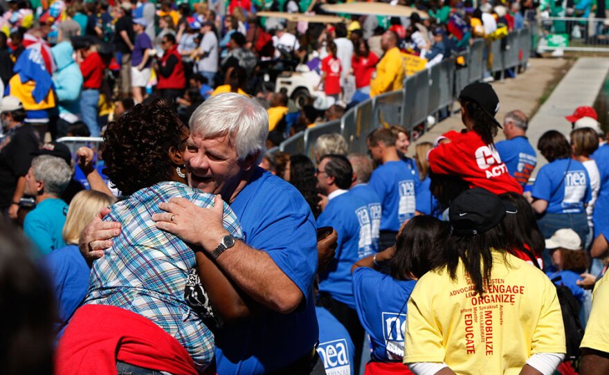 Erica DeVose, left, of Philadelphia, is hugged by Mike Crossey, of Pittsburgh, while attending the "One Nation Working Together" rally.