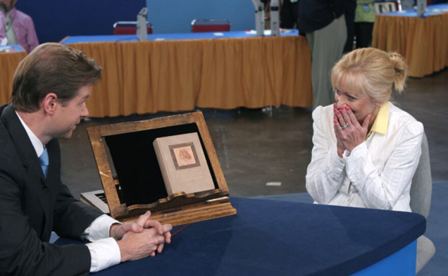 At "Antiques Roadshow" in Providence, Rhode Island, appraiser Francis Wahlgren of Christie's (left) uncovers a copy of the book "Anne of Green Gables," bought at a flea market for about $5 and since stored in an attic. The owner and her daughter fell in love with the story, having seen the series on PBS, and the owner's appreciation only intensifies as she learns the volume is a rare 1908 first edition valued at $12,000 to $18,000.