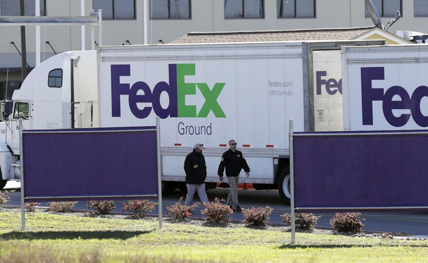Bureau of Alcohol, Tobacco, Firearms and Explosives agents investigate the scene at a FedEx distribution center where a package exploded on Tuesday, in Schertz, Texas. Authorities believe the package bomb is linked to the recent string of Austin bombings.