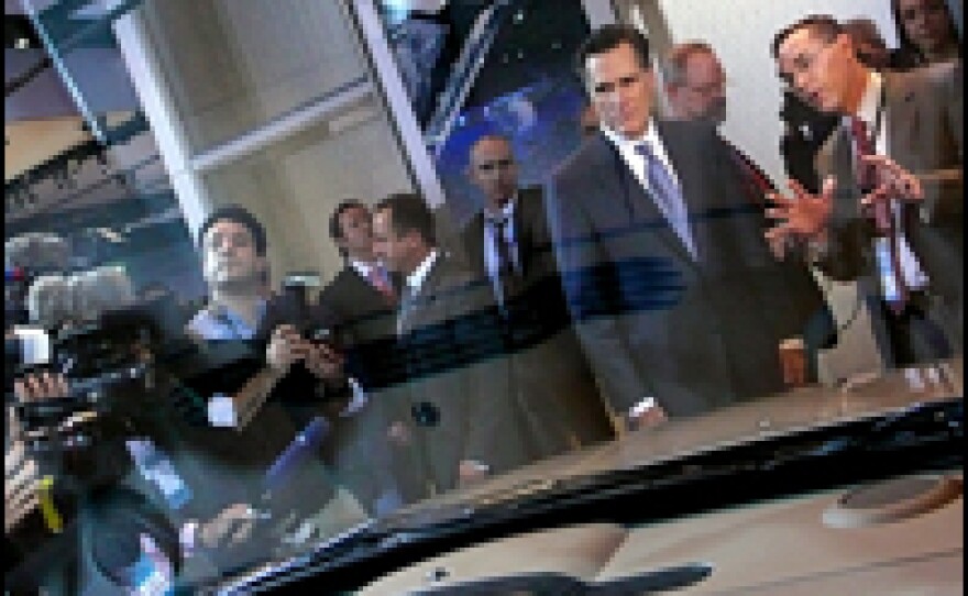Former Massachusetts Gov. Mitt Romney looks over a Chrysler while visiting the North American International Auto Show downtown Detroit on Monday. All the Republican hopefuls visited the auto show the day before the state's primary.